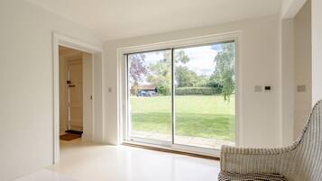A modern interior with a large sliding glass door leading to a garden.