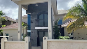 A modern multi-story residential building with a central entrance, a balcony, and a stone facade. - Royal Villa 4-bedroom Villa-January 15, 2027-January 22, 2027 (Cofresi)