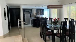 A modern kitchen with dark cabinets, a refrigerator, and a dining area with a table and chairs. - Royal Villa 4-bedroom Villa-January 15, 2027-January 22, 2027 (Cofresi)