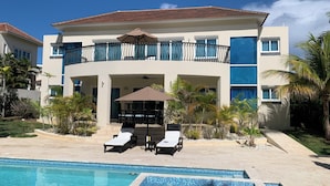 A modern hotel with a pool, outdoor seating, and a two-story structure. - Royal Villa 4-bedroom Villa-January 15, 2027-January 22, 2027 (Cofresi)
