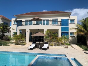 A modern hotel with a pool, outdoor seating, and a two-story structure. - Royal Villa 4-bedroom Villa-January 15, 2027-January 22, 2027 (Cofresi)
