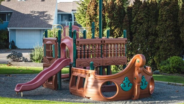 Ein Spielplatz mit Rutsche, Klettergerüsten und einem Spielbereich im Schiff-Design.