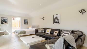 A modern bedroom with a bed, a sofa, and a coffee table.
