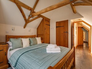 A bedroom with a wooden bed, a wooden wardrobe, and a wooden door. - 2 Bed in Holt (oc-ncc39) (Cley next the Sea)