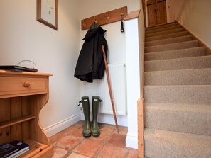 A staircase with carpeted steps, a wooden handrail, and a wooden wall with a coat rack and boots. - 1 Bed in King's Lynn (oc-73108) (West Rudham)