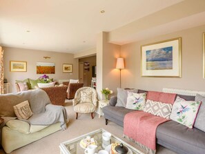A living room with a sofa, armchairs, a coffee table, and a lamp. - 5 Bed in Hunstanton (oc-kt185) (Sedgeford)
