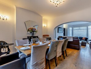 A dining area with a wooden table set for four, surrounded by upholstered chairs. - 5 Bed in Hunstanton (oc-79532) (Hunstanton)