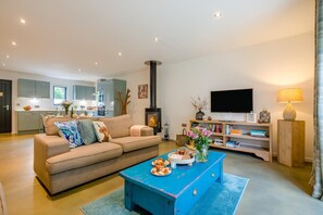 Ein modernes Wohnzimmer mit einer Couch, einem Couchtisch und einem Fernseher.