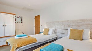 Ein Hotelzimmer mit zwei Betten, einem Kleiderschrank und einem Spiegel an der Wand.