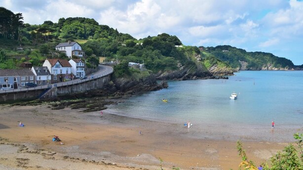 A coastal town with a beach, a road curving along the shore, and houses on a hillside. - 6 Bed in Ilfracombe (oc-52585) (Combe Martin)