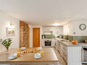 A compact kitchen with white cabinets, a microwave, and a sink. - 3 Bed in Ilfracombe (oc-47348) (Berrynarbor)