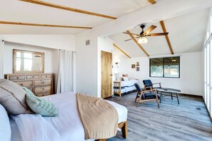 A bedroom with a bed, a dresser, a chair, a table, and a ceiling fan. - Hi View House - Desert Lookout with Fire Pit (Joshua Tree)