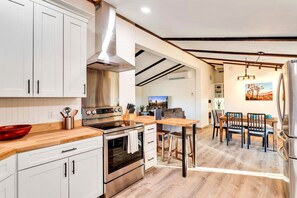 A modern kitchen with white cabinets, stainless steel appliances, and a wooden countertop. - Hi View House - Desert Lookout with Fire Pit (Joshua Tree)