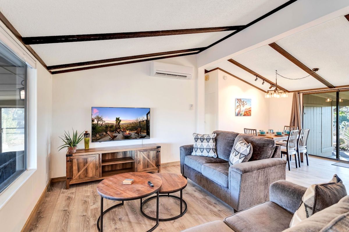 Una sala de estar moderna con un sofá, una mesa de centro y un televisor montado en la pared.