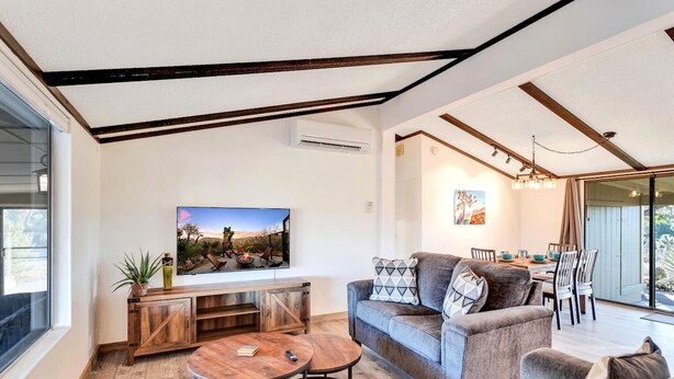 Un salon moderne avec un canapé, une table basse et un téléviseur fixé au mur.