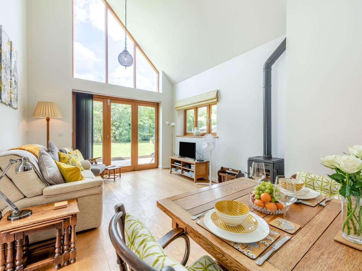 A spacious living area with a sofa, dining table, and a television.