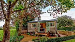 A wooden cabin with a porch, a small deck, and a pathway leading to it. - 1 Bed in Tewkesbury (oc-94686) (Bushley)