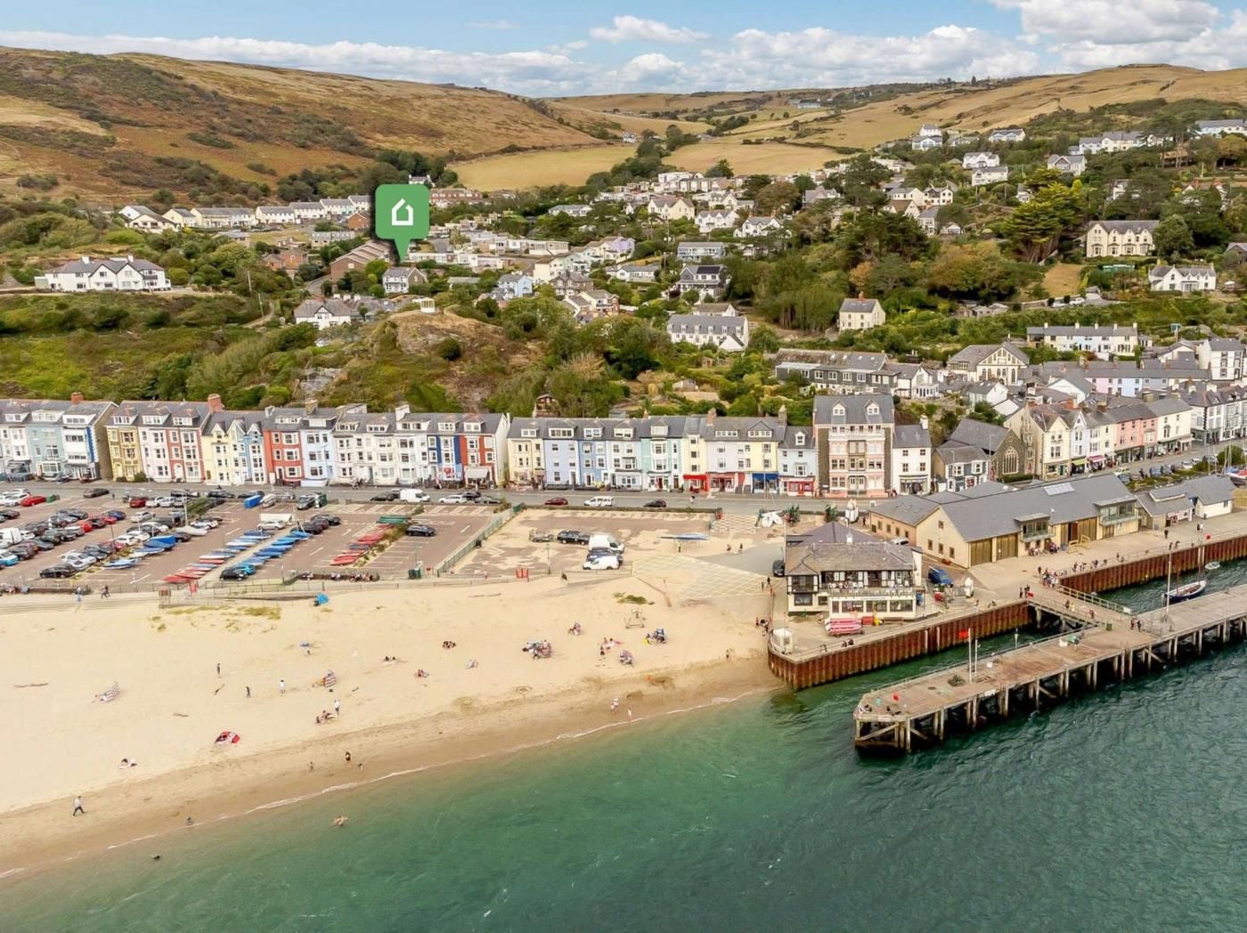 A coastal town with a beach, a pier, and colorful buildings.
