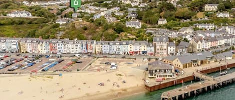 A coastal town with a beach, a pier, and colorful buildings.