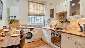 A compact kitchen with a washing machine, a stove, and a sink. - 2 Bed in Keswick (oc-94995) (Keswick)
