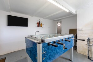 A room with a foosball table, a television mounted on the wall, and a radiator. - 6 Bed in Bideford (oc-beaho) (Bideford)