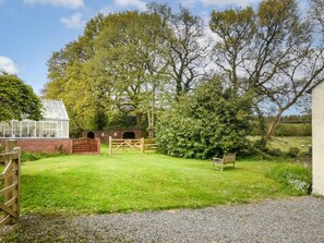A green lawn with a wooden bench, a brick structure, and a wooden gate. - 1 Bed in Launceston (oc-85158) (Launceston)