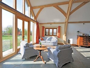 A spacious room with large windows, a wooden ceiling, striped furniture, and a stone floor. - 1 Bed in Somerton (oc-asher) (Compton Dundon)