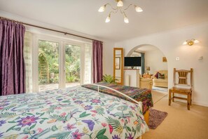 Ein Schlafzimmer mit einem großen Bett, einem Fernseher und Blick ins Freie.