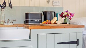 A kitchenette with a toaster, kettle, and a small fruit display. - 1 Bed in Fowey (oc-95015) (Golant)