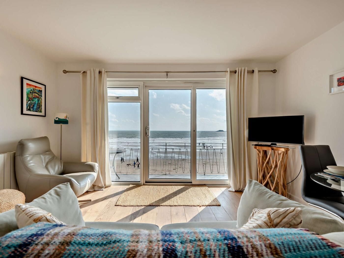 Une chambre d’hôtel avec vue sur la plage, une télévision et un canapé.