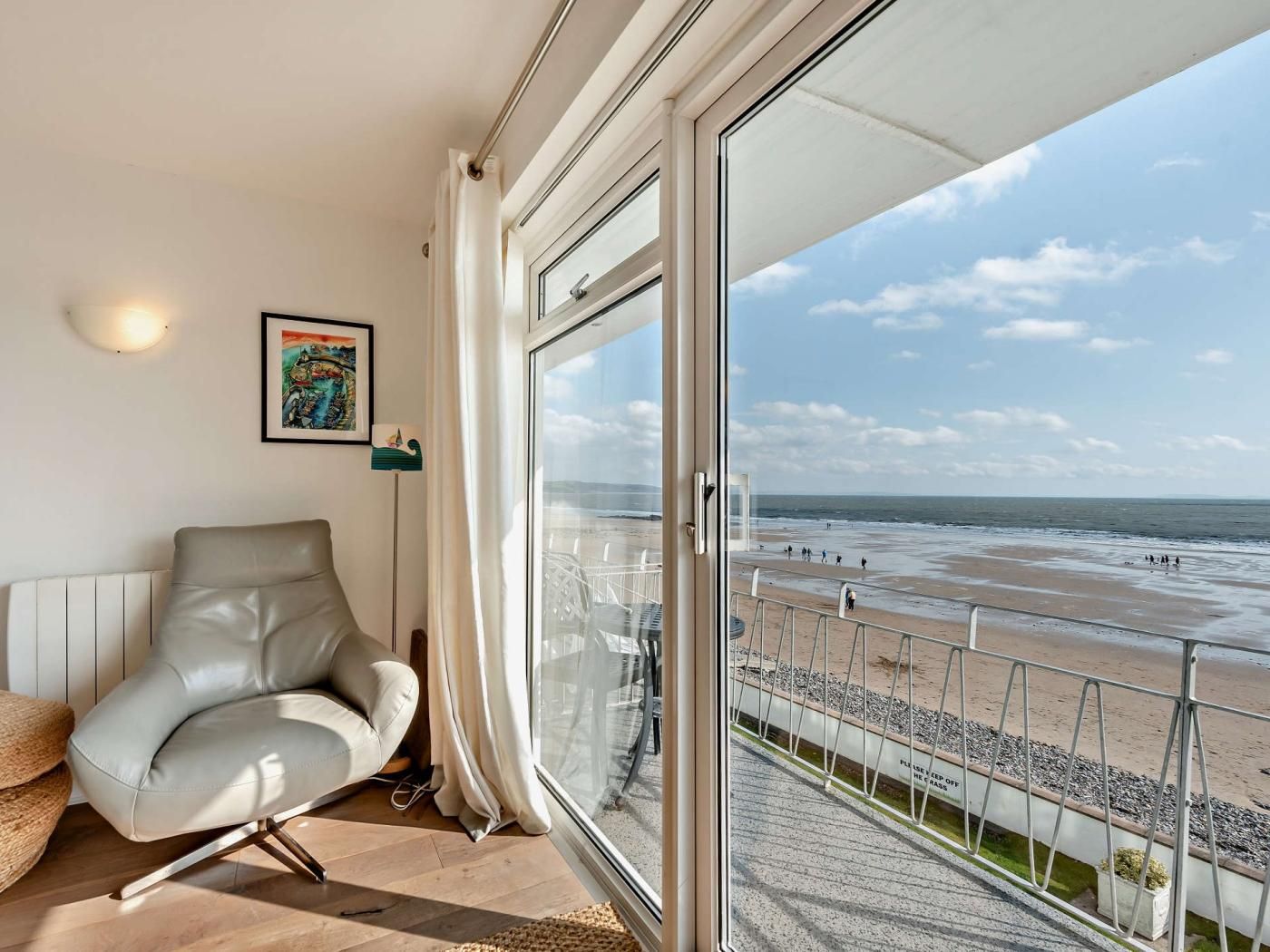 A balcony with a view of the beach and ocean.