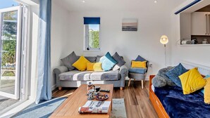 Un salon moderne avec un canapé, une table basse et un lit.