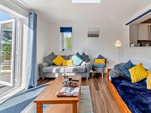 A modern living room with a sofa, a coffee table, and a bed. - 3 Bed in Saundersfoot (oc-83465) (Saundersfoot)