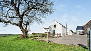 A rural property with a large tree, a white building with a stone extension, and a paved driveway. - 2 Bed in Narberth (oc-72864) (Whitland)