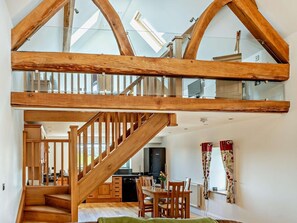 A spacious loft with a wooden staircase, a kitchen, and a dining area. - 1 Bed in Narberth (oc-72867) (Whitland)