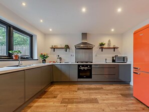 A modern kitchen with a built-in oven, a microwave, and a gas stove. - 2 Bed in Saundersfoot (oc-fb271) (Saundersfoot)