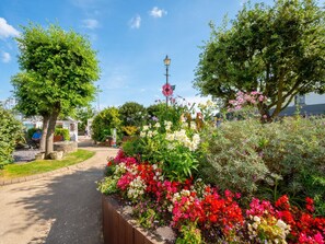 A garden pathway with a variety of flowering plants and trees. - 2 Bed in Saundersfoot (oc-fb271) (Saundersfoot)