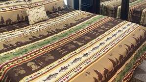 Un dormitorio con una cama grande, un televisor y un espejo.