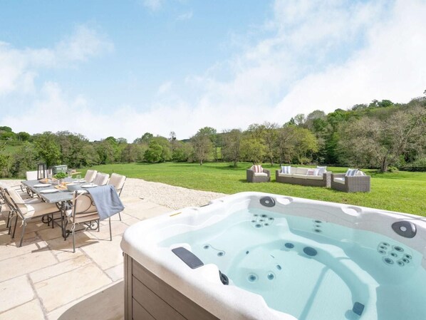 An outdoor hot tub with a dining area and seating. - 4 Bed in Wrexham (oc-87675) (Pont-y-blew)
