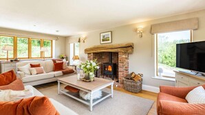 A living room with a fireplace, sofa, television, and large windows. - 4 Bed in Wrexham (oc-87675) (Pont-y-blew)
