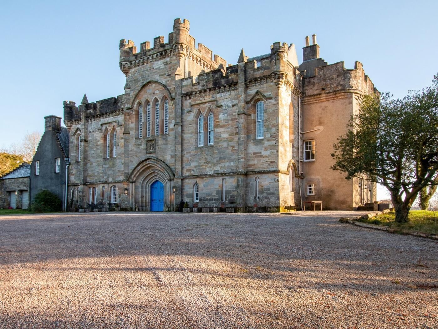 A large, historic stone building with a prominent entrance, multiple windows, and a symmetrical facade.