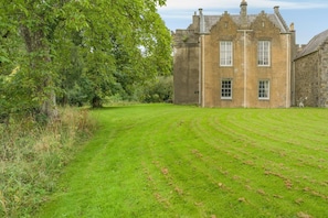 A large stone building with a well-maintained lawn in front.