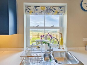A kitchen with a window, a sink, a dish rack, and a view of the countryside. - 2 Bed in Richmond (oc-94997) (Kirby Hill)