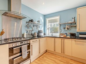 A modern kitchen with stainless steel appliances, wooden flooring, and light blue walls. - 2 Bed in Weymouth (oc-95037) (Weymouth)