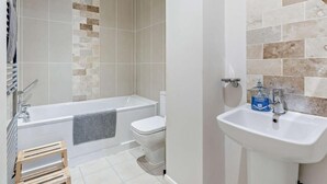 Un baño moderno con bañera, inodoro y lavamanos.