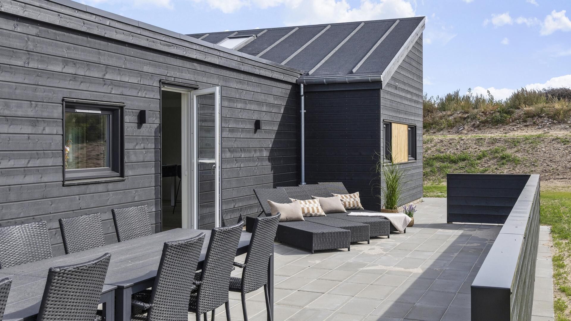A modern outdoor patio with a dining area and seating.