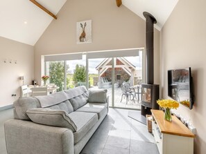 Una sala de estar moderna con un sofá, una chimenea y un televisor.