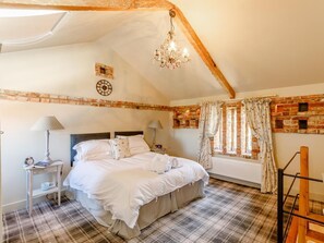 A bedroom with a bed, a nightstand, a lamp, a clock, a window with curtains, and a brick wall. - 2 Bed in York (oc-g0154) (Ellerton)
