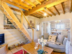 A spacious living area with a wooden staircase, a sofa set, a coffee table, and a kitchen in the background. - 2 Bed in York (oc-g0154) (Ellerton)