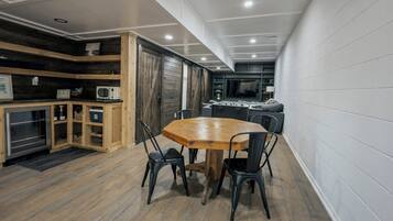 A compact kitchen with a dining table and chairs, wooden cabinets, and a microwave.